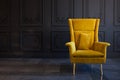 Stylish bright yellow chair against a dark gray wall Royalty Free Stock Photo