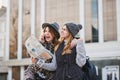 Stylish brightful image of amazing excited joyful girls travelling with citymap, backpack in sunny city. Expressing