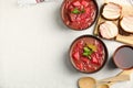 Stylish brown clay bowl with Ukrainian borsch served on white tablecloth, flat lay. Space for text Royalty Free Stock Photo