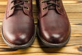 Stylish brown leather boots for men on wooden background, close-up view. Royalty Free Stock Photo