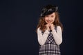 Stylish brunette kid is posing in studio on a black background. Children`s fashion. Royalty Free Stock Photo