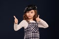 Stylish brunette kid is posing in studio on a black background. Children`s fashion. Royalty Free Stock Photo