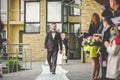 Stylish brunette smiling groom in a suit with a brown bow holds Royalty Free Stock Photo