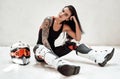 Stylish brunette with tattoo, in a tracksuit posing in a white photo studio Royalty Free Stock Photo