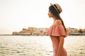 Stylish brunette woman enjoying sunrise on seafront