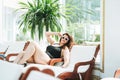 Stylish brunette woman plus size body positive in black swimsuit and sunglasses enjoying her life on lounger in spa Royalty Free Stock Photo