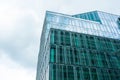 Stylish building with many windows under cloudy sky, low angle view