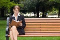 Stylish business woman siting on park bench writing in notebook Royalty Free Stock Photo