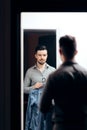 Stylish Man Checking Himself in the Mirror Trying on Clothes