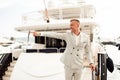 Stylish businessman is standing on his luxury yacht is wearing fashion costume. Montenegro bay Royalty Free Stock Photo