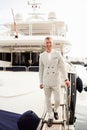 Stylish businessman is standing on his luxury yacht is wearing white fashion costume. Montenegro bay Royalty Free Stock Photo