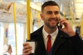 Stylish businessman talking on the phone in public transportation Royalty Free Stock Photo