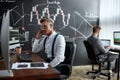 Invest Today, Earn Tomorrow. Stylish businessman, trader sitting in front of computer monitor while working using