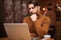 Stylish businessowman reading an email on his laptop while being in a coffee shop Royalty Free Stock Photo