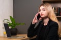 Stylish businesswoman chatting on a mobile phone in an office Royalty Free Stock Photo