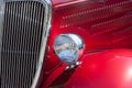 Stylish candy apple red hot rod close-up of fender, grille, hood