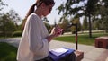 Stylish caucasian woman in a white blouse and glasses is typing a message on the phone. Electric scooter, business