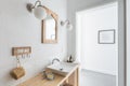 Ceramic sink on trendy wooden console table in small elegant bathroom