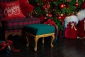 Stylish Checkered armchair with green pouf. Cozy armchair with ottoman in interior room. Red sack santa with gifts near Christmas