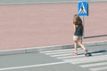 Stylish child in fashion clothes is walking along summer city crosswalk. Kid on pedestrian side walk. Concept pedestrians passing Royalty Free Stock Photo