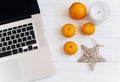 Stylish christmas flat lay. laptop and oranges and golden star a Royalty Free Stock Photo