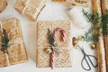 Stylish christmas gift flat lay. Modern christmas gift box with candy cane, fir branch, festive paper and golden ornaments