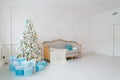 Stylish Christmas interior with an elegant sofa. Comfort home. Presents gifts underneath the tree in living room Royalty Free Stock Photo