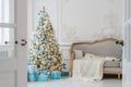 Stylish Christmas interior with an elegant sofa. Comfort home. Presents gifts underneath the tree in living room Royalty Free Stock Photo
