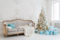 Stylish Christmas interior with an elegant sofa. Comfort home. Presents gifts underneath the tree in living room Royalty Free Stock Photo