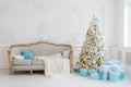 Stylish Christmas interior with an elegant sofa. Comfort home. Presents gifts underneath the tree in living room Royalty Free Stock Photo