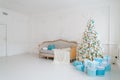 Stylish Christmas interior with an elegant sofa. Comfort home. Presents gifts underneath the tree in living room Royalty Free Stock Photo