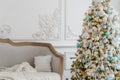 Stylish Christmas interior with an elegant sofa. Comfort home. Presents gifts underneath the tree in living room Royalty Free Stock Photo