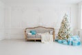 Stylish Christmas interior with an elegant sofa. Comfort home. Presents gifts underneath the tree in living room Royalty Free Stock Photo