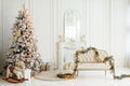 Stylish Christmas light interior with a soft armchair or sofa decorated with garland