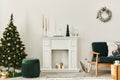 Stylish christmas living room interior with green sofa, white chimney, christmas tree and wreath, gifts and decoration.