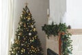 Stylish christmas living room with modern decorated christmas tree with vintage baubles and scandinavian decor on fireplace mantel