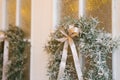 Stylish Christmas wreath with a satin bow on the white entrance doors of a country house close-up Royalty Free Stock Photo