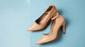 Stylish classic womens beige leather shoes with medium high heels, side shot on pink blue multi-colored paper background.