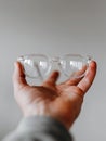 Stylish Clear-Frame Glasses Held by a Man Against a Neutral Backdrop With Space for Text Royalty Free Stock Photo