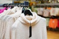 Stylish clothes on hangers in the store, white sweaters Royalty Free Stock Photo