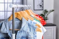 Stylish clothes hanging on wardrobe rack indoors