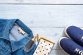 Stylish clothing look in flat lay style on blue pastel colored wooden desk