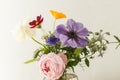 Stylish colorful flowers bouquet on rustic wall background. Beautiful summer wildflowers, anemones and roses in vase gathered from Royalty Free Stock Photo