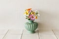 Stylish colorful wildflowers bouquet on tile shelf on rustic wall background. Beautiful summer flowers in vase gathered from Royalty Free Stock Photo