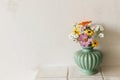 Stylish colorful wildflowers bouquet on tile shelf on rustic wall background. Beautiful summer flowers in vase gathered from Royalty Free Stock Photo