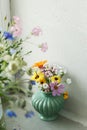 Stylish colorful wildflowers bouquet on tile shelf on rustic wall background. Beautiful summer flowers in vase gathered from Royalty Free Stock Photo