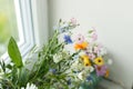 Stylish colorful wildflowers bouquet on tile shelf on rustic wall background. Beautiful summer flowers in vase gathered from Royalty Free Stock Photo