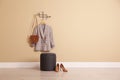 Stylish comfortable pouf near beige wall in hallway, space for text