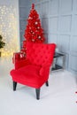 Stylish comfortable red chair on legs in a New Year\'s interior Royalty Free Stock Photo