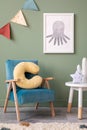 Stylish composition of cozy child room interior design with green wall and armchairs and stool. Mock up. Blue armchair, posters, Royalty Free Stock Photo